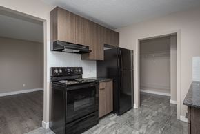Edmonton apartment for rent - A kitchen with a black stove top oven and black refrigerator.
