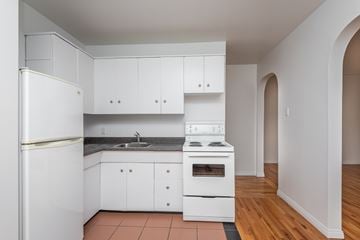 Edmonton apartment for rent - A kitchen with white appliances and cabinets.