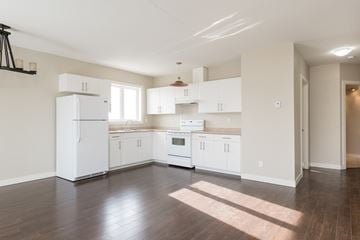 Edmonton apartment for rent - A kitchen with white appliances and cabinets.