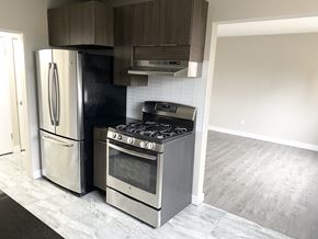 Edmonton apartment for rent - A kitchen with a black fridge, stainless steel oven and a black and white tiled backsplash.