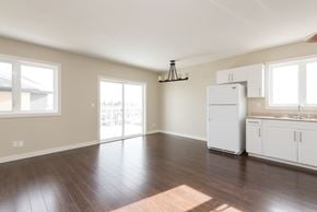 Edmonton apartment for rent - A kitchen with white appliances and wooden floors.