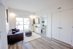Edmonton apartment for rent - A living room with a couch, a table, and a large window.