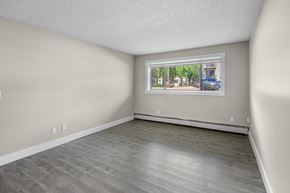 Edmonton apartment for rent - Empty room with a window showing a street view.