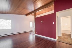 Edmonton apartment for rent - A room with wooden floors and a red wall.