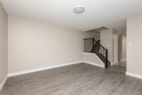 Edmonton apartment for rent - A spacious room with a staircase leading to the upper floor.