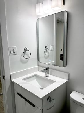 Edmonton apartment for rent - A white bathroom sink with a mirror above it.