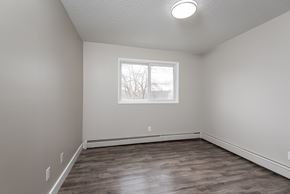 Edmonton apartment for rent - A room with a window and wooden flooring.