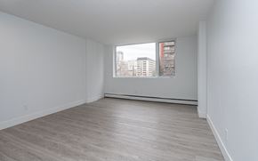 Edmonton apartment for rent - Empty room with a window overlooking a cityscape.
