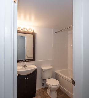 Edmonton apartment for rent - A white toilet sits next to a sink in a bathroom.