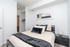 Edmonton apartment for rent - A bedroom with a bed, nightstand, and lamp.