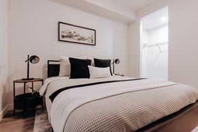Edmonton apartment for rent - A bedroom with a large bed and a painting on the wall.