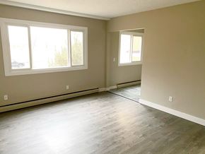 Edmonton apartment for rent - A room with light wood flooring and two windows.