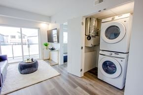Edmonton apartment for rent - A modern laundry room with a washer and dryer stacked on top of each other.
