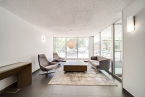 Edmonton apartment for rent - A living room with a brown sofa, grey armchair, and a coffee table.