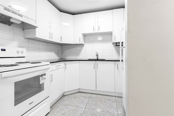 Edmonton apartment for rent - A white kitchen with a stove, oven, and cabinets.