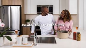 Edmonton apartment for rent - A man and woman are standing in a kitchen with a text overlay that says "ASK ABOUT OUR 1 & 2 BED SUITES!".