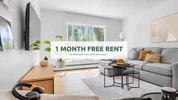 Edmonton apartment for rent - A living room with a grey sofa and a coffee table, and a sign that says "1 MONTH FREE RENT".