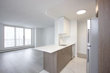 Edmonton apartment for rent - A kitchen with a white counter top and wooden cabinets.