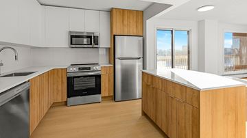 Edmonton apartment for rent - A modern kitchen with wooden cabinets and stainless steel appliances.