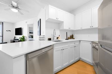 Edmonton apartment for rent - A modern kitchen with white cabinets and stainless steel appliances.