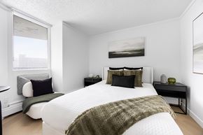 Edmonton apartment for rent - A bedroom with a large bed and a green blanket.