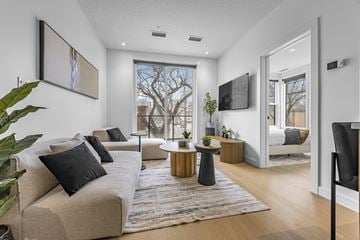 Edmonton apartment for rent - A living room with a beige couch and a large window.