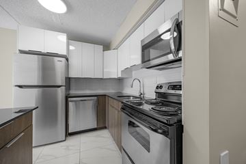 Edmonton apartment for rent - A modern kitchen with stainless steel appliances and white cabinets.