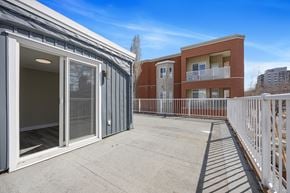 Edmonton apartment for rent - A balcony with a railing and a building in the background.