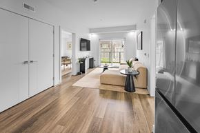 Edmonton apartment for rent - A modern living room with a wooden floor and a large window.