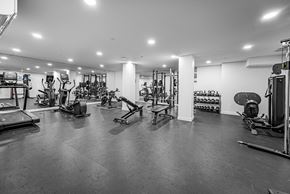 Edmonton apartment for rent - A black and white image of a gym with various exercise equipment.