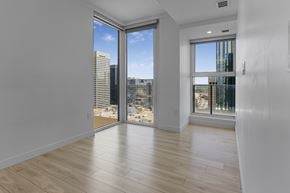 Edmonton apartment for rent - A spacious room with a view of the cityscape through the windows.