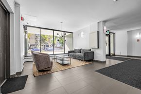 Edmonton apartment for rent - A spacious waiting room with a brown chair and grey couch.
