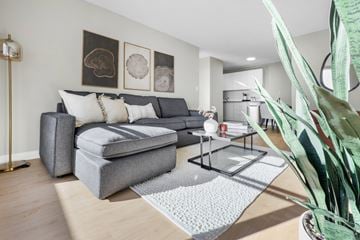 Edmonton apartment for rent - A living room with a grey couch and a grey ottoman.