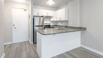 Edmonton apartment for rent - A modern kitchen with white cabinets and a stainless steel refrigerator.