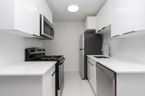 Edmonton apartment for rent - A modern kitchen with black appliances and white cabinets.