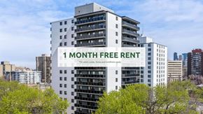 Edmonton apartment for rent - A tall white building with a sign that says "1 MONTH FREE RENT" in front of it.