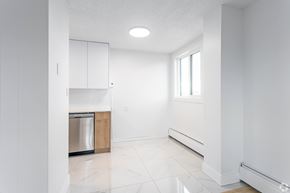 Edmonton apartment for rent - A white kitchen with a dishwasher and a window.