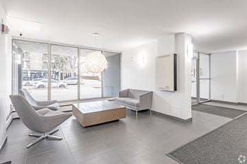 Edmonton apartment for rent - A modern living room with a grey chair and a white sofa.