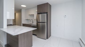Edmonton apartment for rent - A modern kitchen with a stainless steel refrigerator and a white countertop.