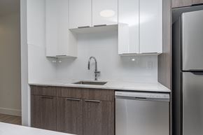 Edmonton apartment for rent - A modern kitchen with a stainless steel dishwasher and white cabinets.