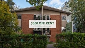 Edmonton apartment for rent - A brick building with a sign that says "$500 OFF RENT" in front of it.