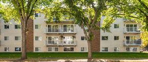 Edmonton apartment for rent - Apartment building with balconies and trees in front.