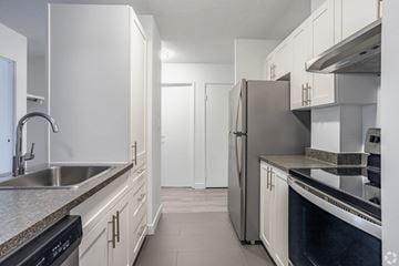 Edmonton apartment for rent - A kitchen with white cabinets and stainless steel appliances.