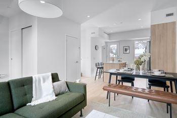 A modern living room with a green couch and a wooden bench.