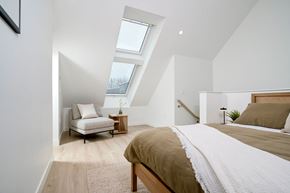 Waterdown apartment for rent - A bedroom with a bed, a chair, and a rug at The Grindstone Apartments, Ontario