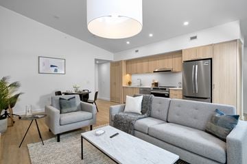 Orillia apartment for rent - A modern living room with a grey couch and a coffee table.