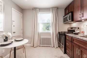 Union apartment for rent - A kitchen with brown cabinets and a white table.