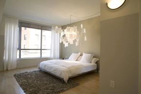 Yonkers apartment for rent - A bedroom with a large bed and a chandelier.at 66 Main, Yonkers
