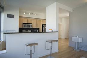 Yonkers apartment for rent - A kitchen with a white counter and bar stools.at 66 Main, Yonkers, 10701