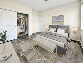 Bound Brook apartment for rent - A bedroom with a large bed and a bench in front of it.